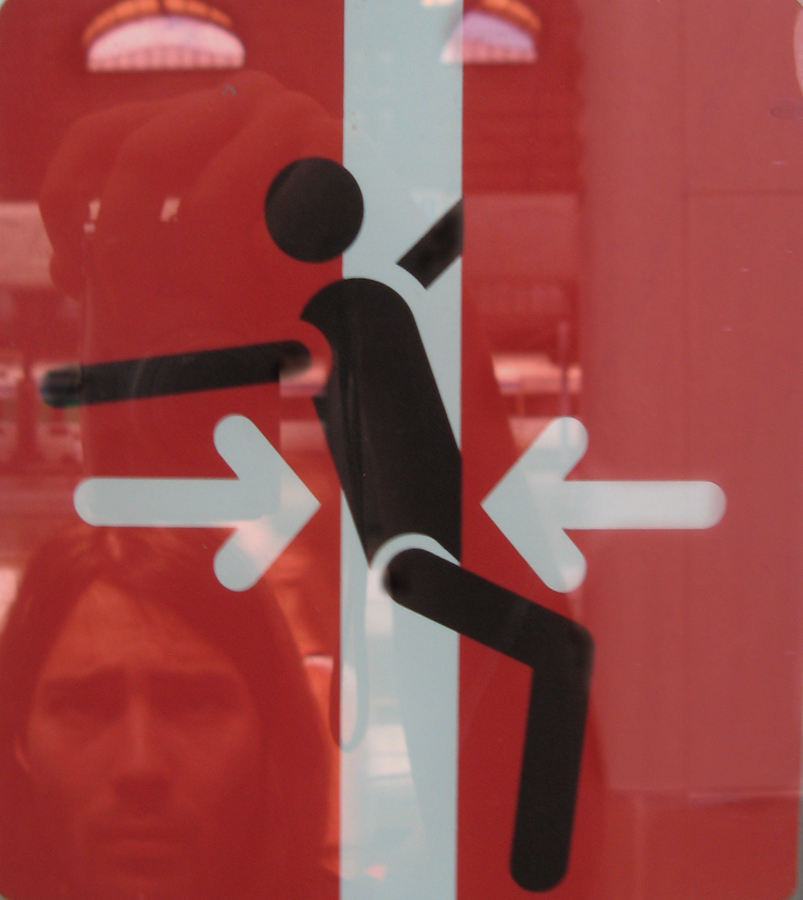 Warning sign of an exiting person getting jammed by train doors, accidentally resembling a dancing pose
